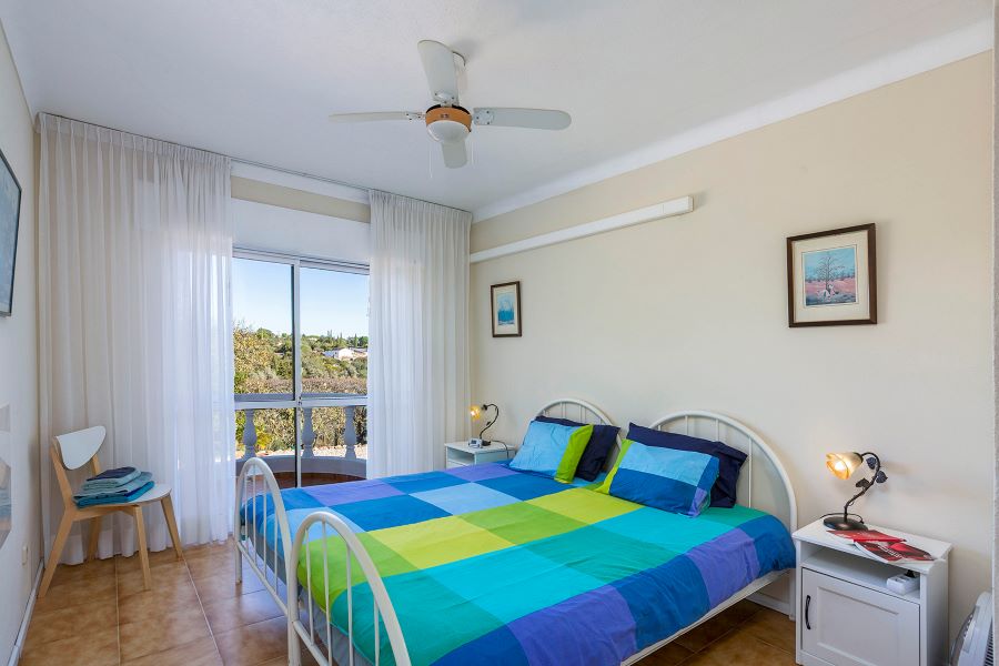 Bedroom with shared bathroom, wifi, ceiling fan, and a small balcony with a beautiful view and heat panels.