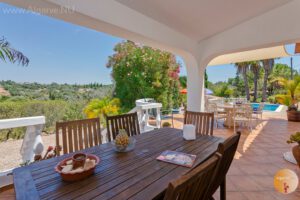 Teilweise überdachte Terrasse mit Zugang zum Pool und zum Wohnzimmer.