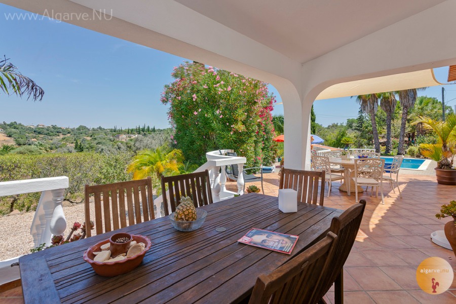 Teilweise überdachte Terrasse mit Zugang zum Pool und zum Wohnzimmer.