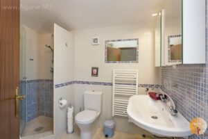 En-suite de la chambre principale avec grand lavabo, toilettes, douche et petite baignoire.
