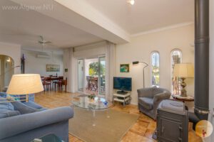 Geräumiges Wohn-Esszimmer mit Türen zur Terrasse mit Pool.