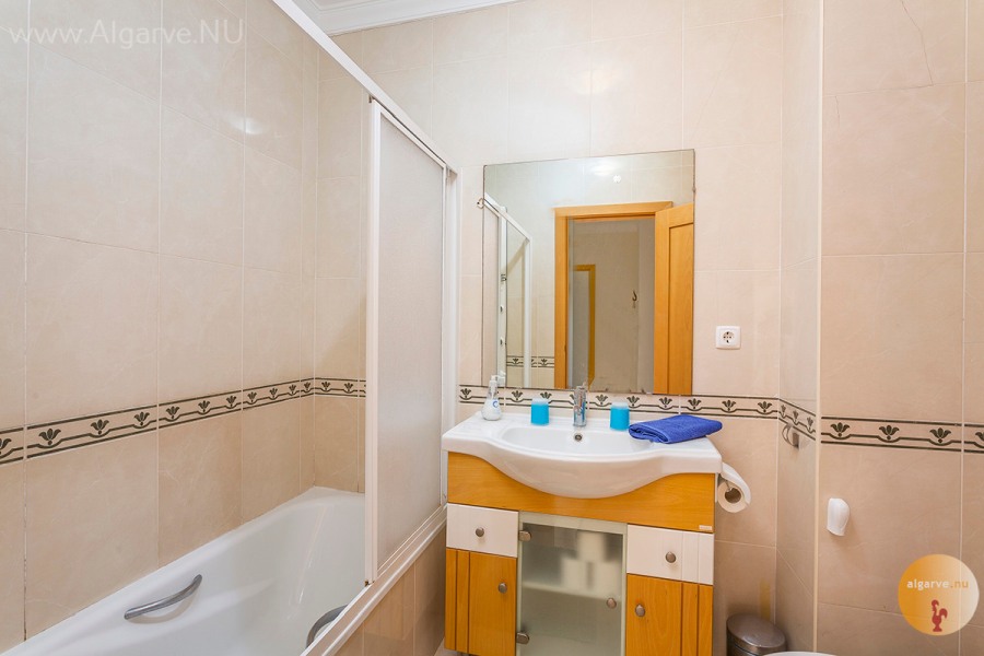 Badkamer met wastafel, toilet, badkuip met hydromassagedouche.