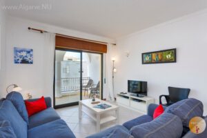 Woonkamer met balkon en uitzicht op de Estrada do Farol, Carvoeiro.