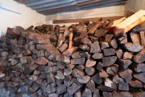 Une grande pile de bûches de bois de chauffage empilées à l'intérieur pour alimenter le poêle.