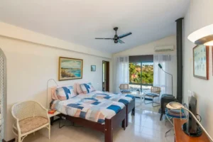 Hoofdslaapkamer met en-suite badkamer, airco, warmtepanelen, openslaande deuren naar de tuin, tv, wifi, plafondventilator.