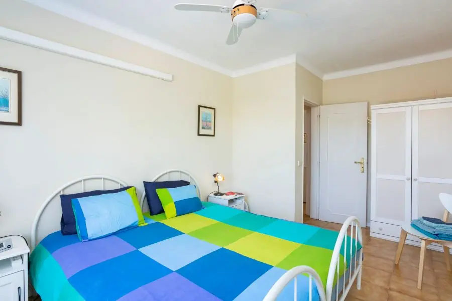 Slaapkamer met gedeelde badkamer, wifi, plafondventilator en een klein balkon met prachtig uitzicht en warmtepanelen.