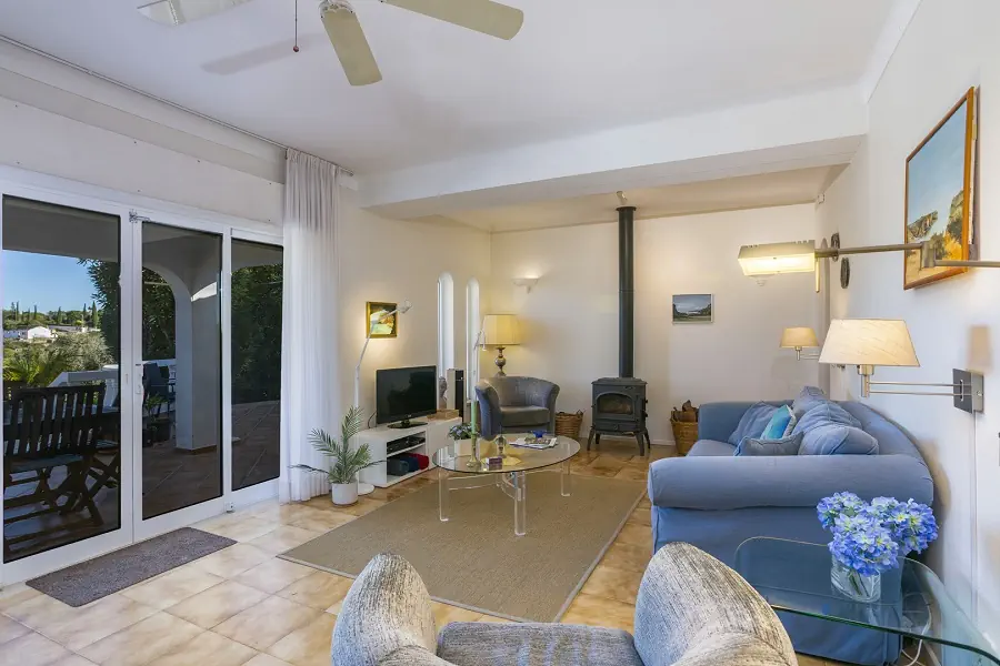 Ruime woonkamer met toegang tot het gedeeltelijk overdekte terras en het zwembad.